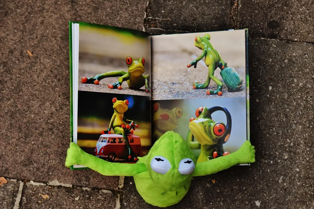 En åben billedbog og en grøn frøbamse